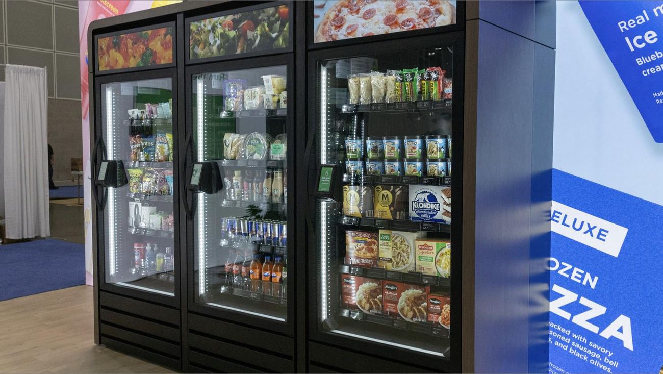 A Skala AI smart cooler bank in custom millwork, digital header screens above each glass door.